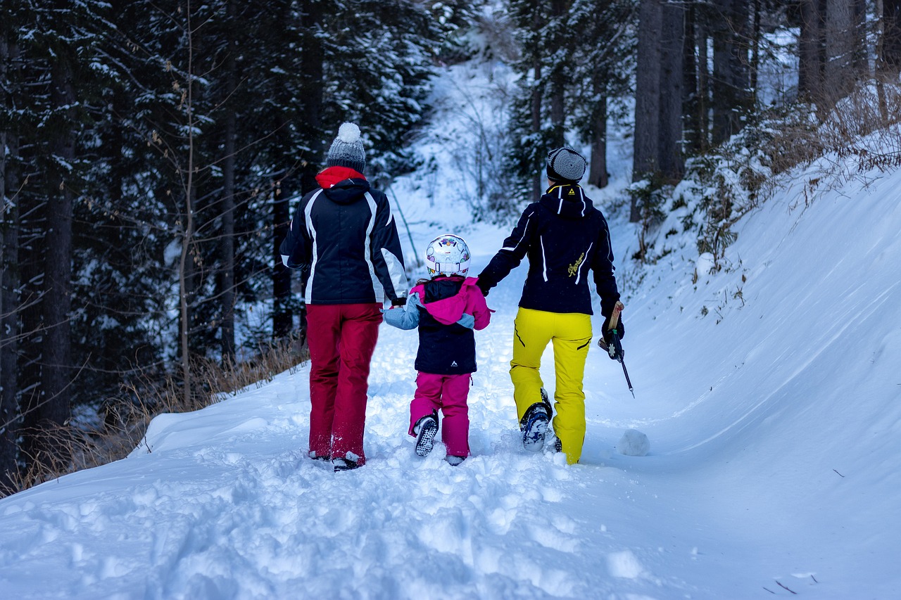 Famille marchant dans une forêt givrée en tenue d'hiver