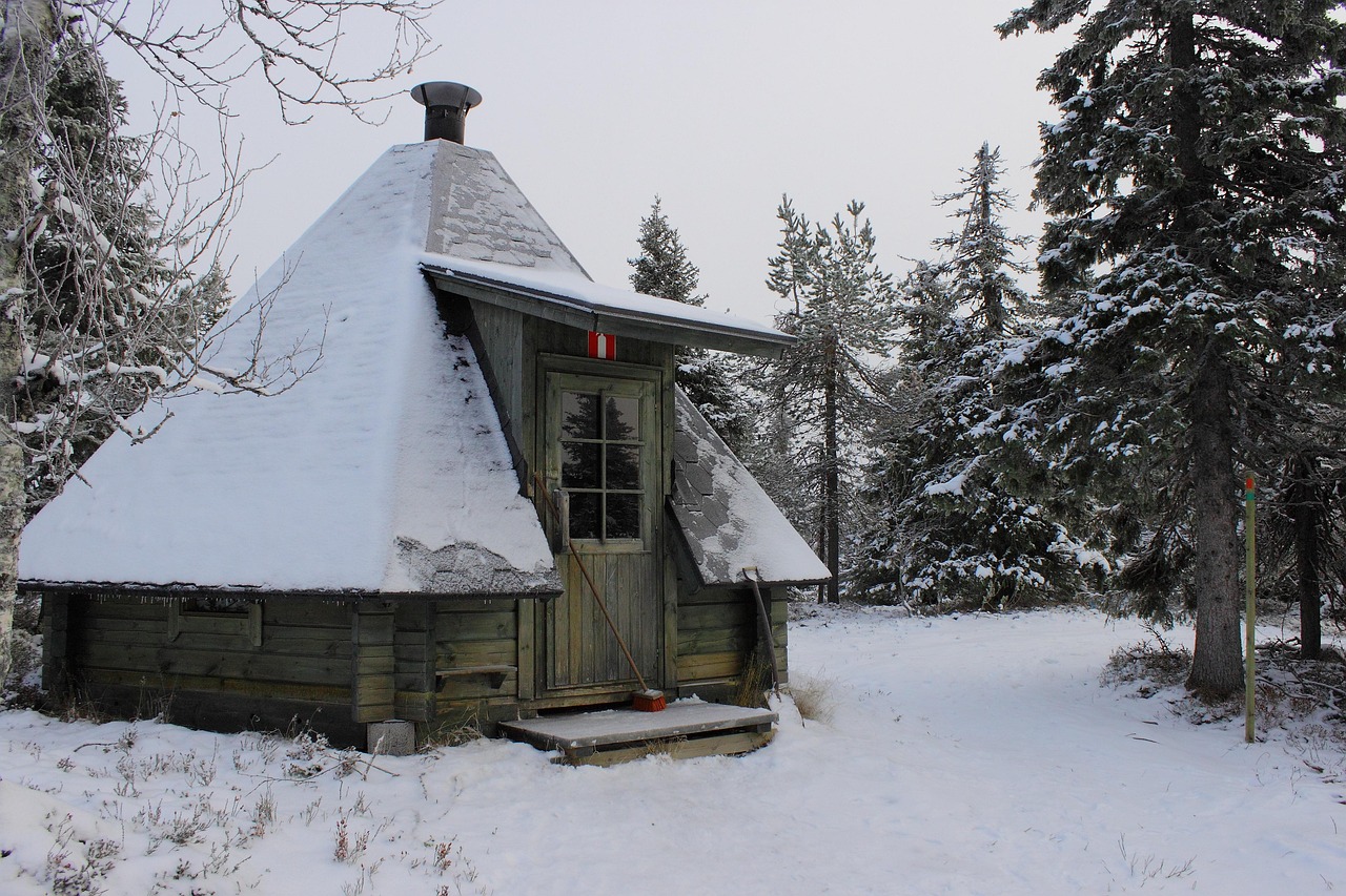 Forêt lapone sous une épaisse couche de neige avec une maison en bois