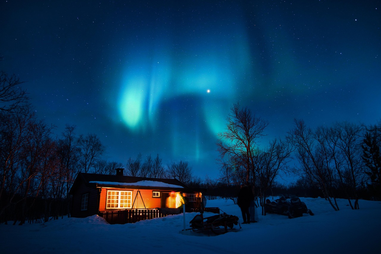 Cabane en bois isolée sous une aurore boréale verte en Laponie