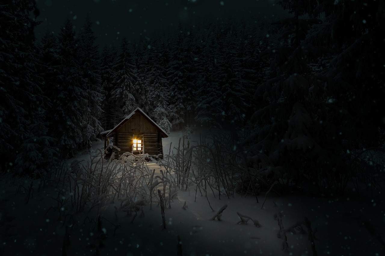 Chalet en bois éclairé la nuit dans la neige en Laponie finlandaise