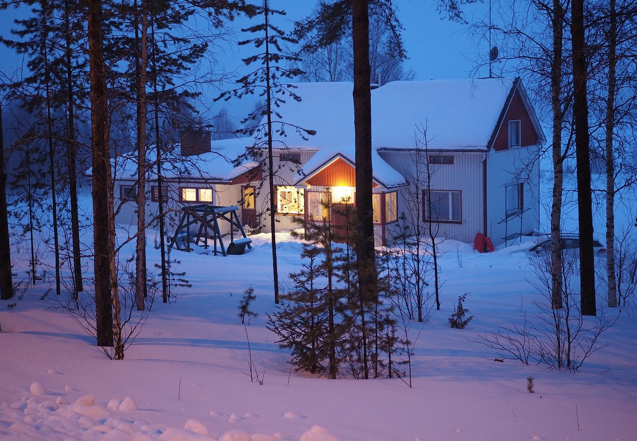 Maison en bois isolée dans une forêt enneigée de Laponie finlandaise, la nuit