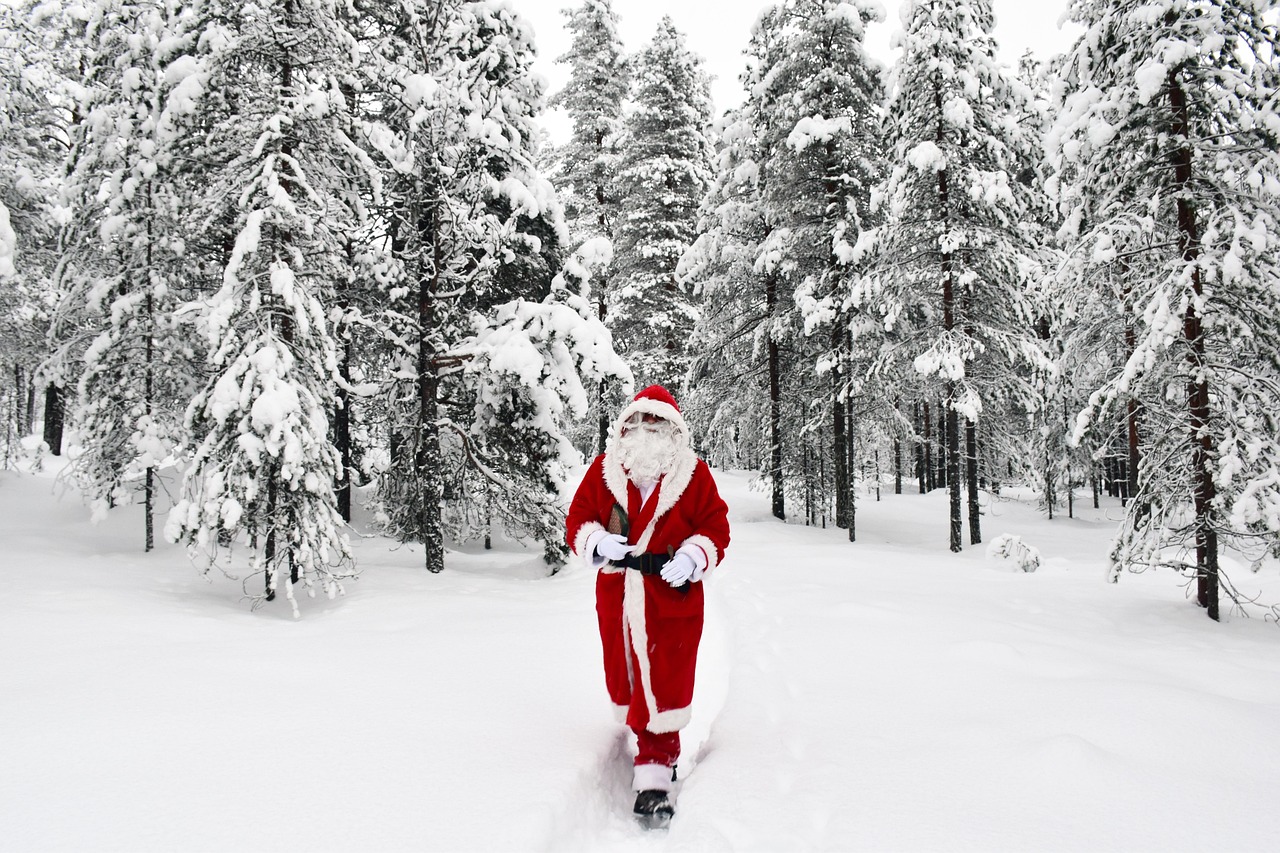 Père Noël en costume rouge dans une forêt enneigée de Laponie finlandaise